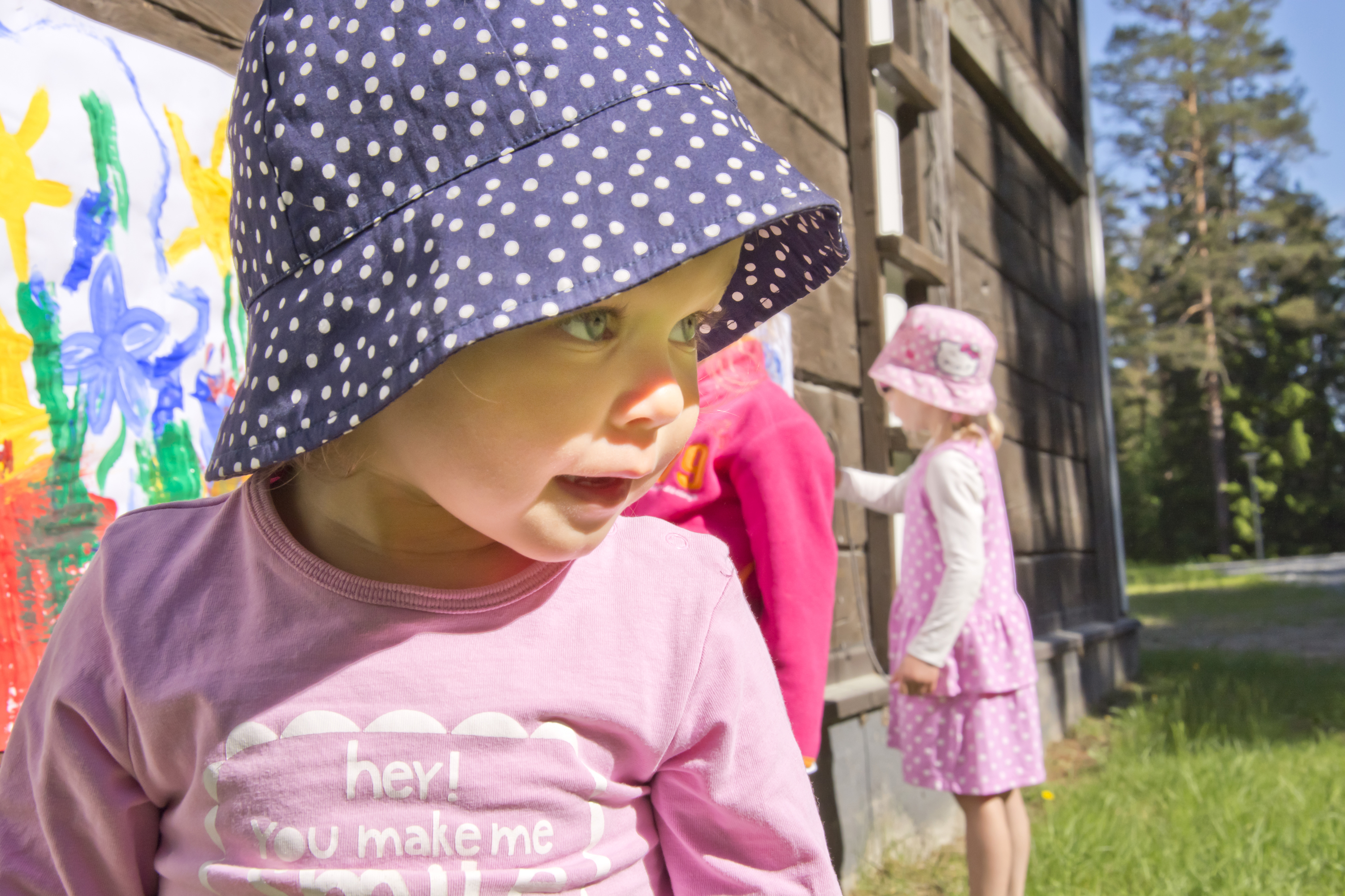 Päiväkerho Lapsi katsoo iloisesti kauniissa kesämaisemassa ympärilleen.